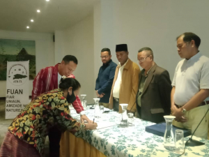 SEKOOP Elizário Ferreira sasin hela ba akta ne’ebé asina husi Dirijente Koperativa Turizmu Relijiosu Timor-Leste, iha salaun Hotel Timor, (21/12).