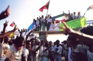 Manifestante 12 Novembru 1991 dada espanduk ho bandeira iha rate Santa Cruz antes TNI halo masakre hasoru demonstrante sira