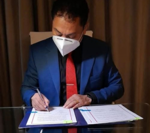 Ministru Turizmu Komérsiu no Indústria José Lucas do Carmo da Silva, asina hela akordu.