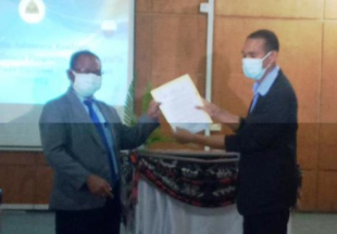Diretor Ezekutivu FDCH, Hermengildo da Silva (karuk) entrega hela kontratu ne&#039;ebé asina ho Estudante benifisiaria sira ba Reitór UNTL, João Soares, iha Auditória UNTL Liceu, tersa (17/08).