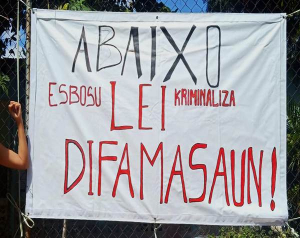 Espanduk ne&#039;ebe tara hela iha lutu besik edifisiu Yayasan HAK Farol Dili