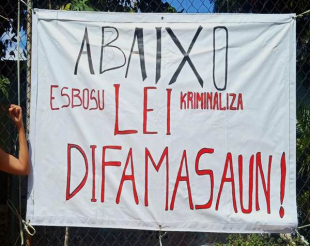 Espanduk ne&#039;ebe tara hela iha lutu besik edifisiu Yayasan HAK Farol Dili